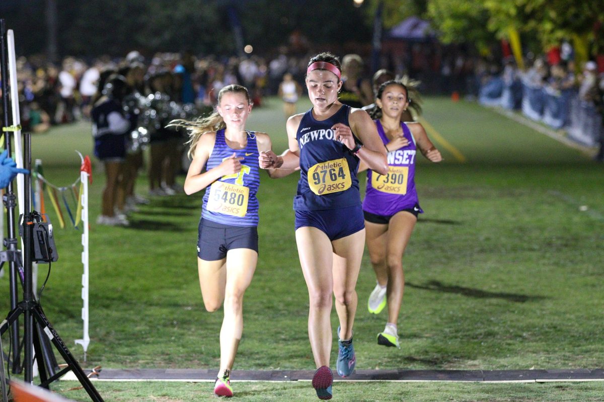 Newport Harbor runner competes in a night cross-country race, from the NHHS XC 2023 album.
