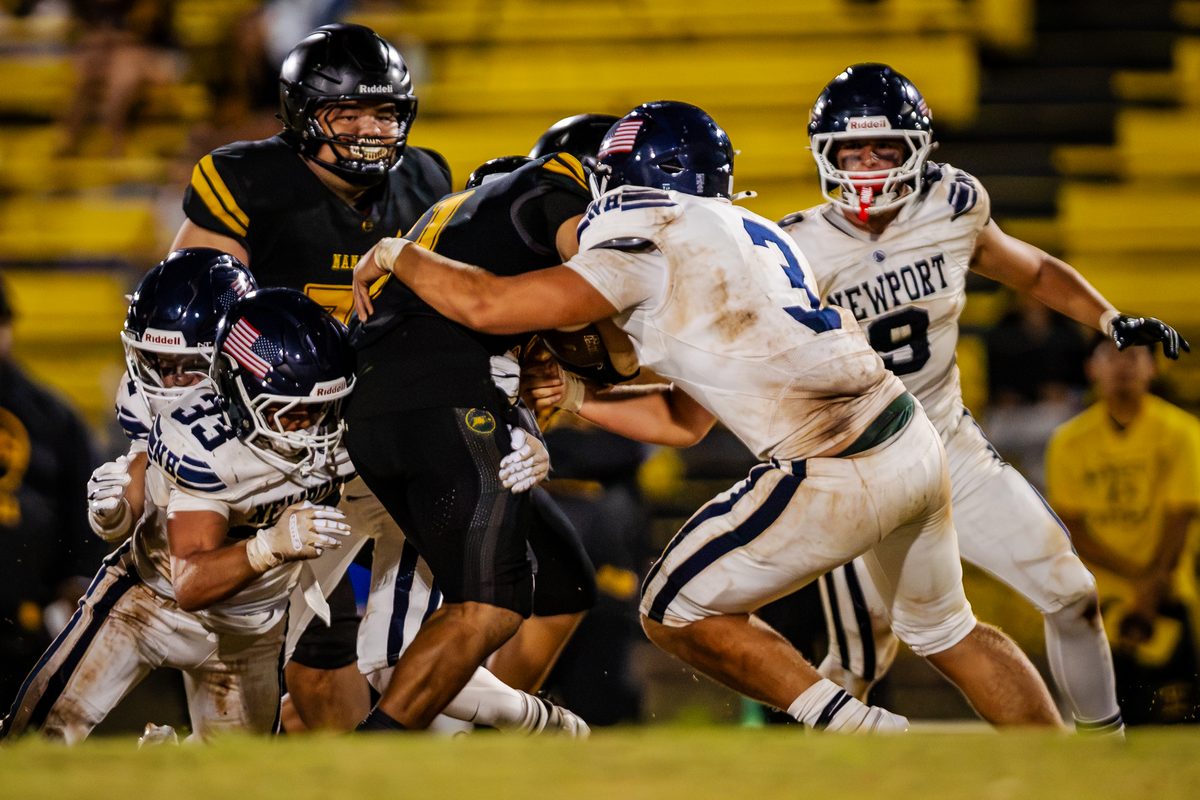 Newport Harbor defenders tackling a Nanakuli player in Oahu, 2026.