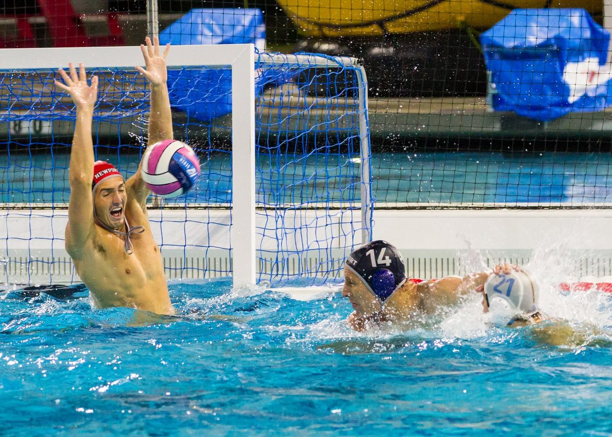 A goalkeeper rises to block a shot from Newport Harbor’s No. 14.